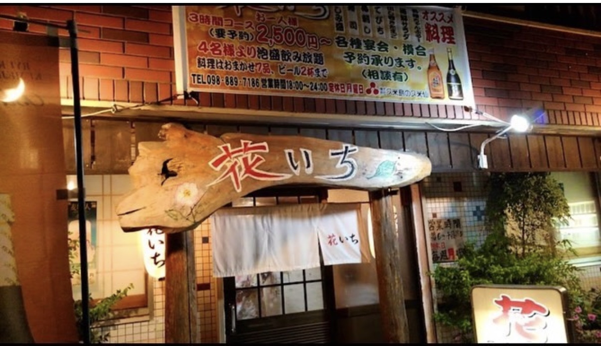 花いちの外観。流木に「花いち」と書かれた看板と白いのれんがかかった入口